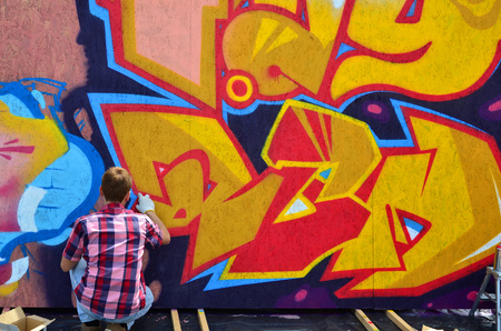 KHARKOV, UKRAINE - MAY 27, 2017: Festival of street arts. Young guys draw graffiti on portable wooden walls in the center of the city. The process of painting on walls with aerosol spray cansのeditorial素材