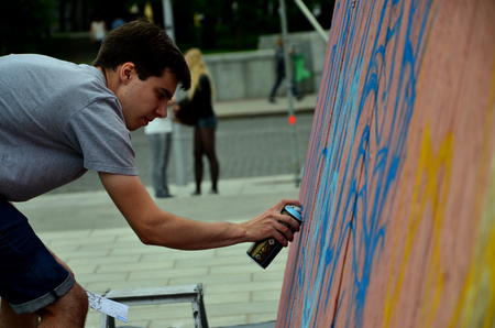 KHARKOV, UKRAINE - MAY 27, 2017: Festival of street arts. Young guys draw graffiti on portable wooden walls in the center of the city. The process of painting on walls with aerosol spray cansのeditorial素材