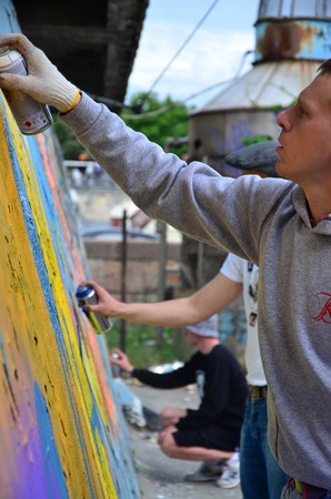 KHARKOV, UKRAINE - MAY 27, 2017: Festival of street arts. Young guys draw graffiti on an old concrete walls in the center of the city. The process of painting on walls with aerosol spray cansのeditorial素材