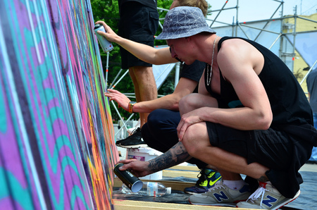 KHARKOV, UKRAINE - MAY 27, 2017: Festival of street arts. Young guys draw graffiti on portable wooden walls in the center of the city. The process of painting on walls with aerosol spray cansのeditorial素材