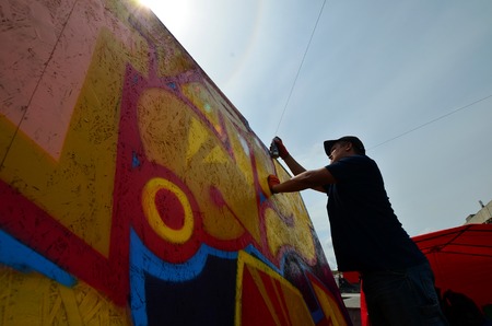 KHARKOV, UKRAINE - MAY 27, 2017: Festival of street arts. Young guys draw graffiti on portable wooden walls in the center of the city. The process of painting on walls with aerosol spray cansのeditorial素材
