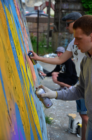 KHARKOV, UKRAINE - MAY 27, 2017: Festival of street arts. Young guys draw graffiti on an old concrete walls in the center of the city. The process of painting on walls with aerosol spray cansのeditorial素材