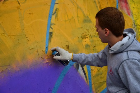KHARKOV, UKRAINE - MAY 27, 2017: Festival of street arts. Young guys draw graffiti on an old concrete walls in the center of the city. The process of painting on walls with aerosol spray cansのeditorial素材