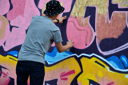 KHARKOV, UKRAINE - MAY 27, 2017: Festival of street arts. Young guys draw graffiti on portable wooden walls in the center of the city. The process of painting on walls with aerosol spray cansのeditorial素材