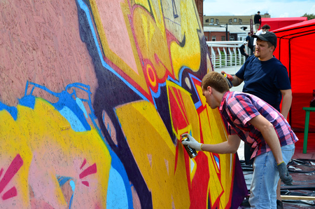 KHARKOV, UKRAINE - MAY 27, 2017: Festival of street arts. Young guys draw graffiti on portable wooden walls in the center of the city. The process of painting on walls with aerosol spray cansのeditorial素材