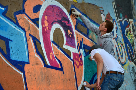 KHARKOV, UKRAINE - MAY 27, 2017: Festival of street arts. Young guys draw graffiti on an old concrete walls in the center of the city. The process of painting on walls with aerosol spray cansのeditorial素材