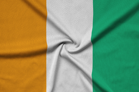 Ivory Coast flag  is depicted on a sports cloth fabric with many folds. Sport team waving bannerの写真素材