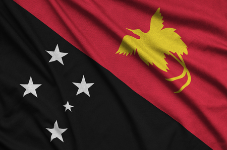 Papua New Guinea flag  is depicted on a sports cloth fabric with many folds. Sport team waving bannerの写真素材