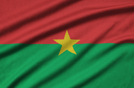 Burkina Faso flag  is depicted on a sports cloth fabric with many folds. Sport team waving bannerの写真素材