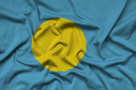 Palau flag  is depicted on a sports cloth fabric with many folds. Sport team waving bannerの写真素材