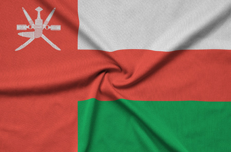 Oman flag  is depicted on a sports cloth fabric with many folds. Sport team waving bannerの写真素材