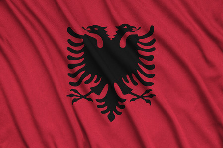 Albania flag  is depicted on a sports cloth fabric with many folds. Sport team waving bannerの写真素材