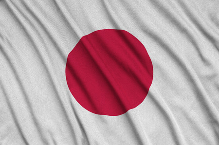 Japan flag  is depicted on a sports cloth fabric with many folds. Sport team waving bannerの写真素材