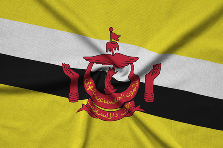 Brunei Darussalam flag  is depicted on a sports cloth fabric with many folds. Sport team waving bannerの写真素材