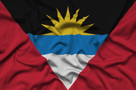 Antigua and Barbuda flag  is depicted on a sports cloth fabric with many folds. Sport team waving bannerの写真素材