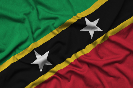 Saint Kitts and Nevis flag  is depicted on a sports cloth fabric with many folds. Sport team waving bannerの写真素材