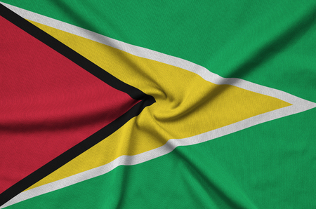 Guyana flag  is depicted on a sports cloth fabric with many folds. Sport team waving bannerの写真素材