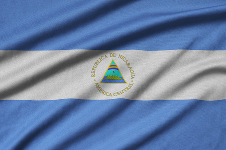 Nicaragua flag  is depicted on a sports cloth fabric with many folds. Sport team waving bannerの写真素材