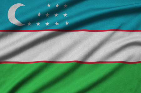 Uzbekistan flag  is depicted on a sports cloth fabric with many folds. Sport team waving bannerの写真素材
