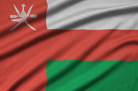 Oman flag  is depicted on a sports cloth fabric with many folds. Sport team waving bannerの写真素材
