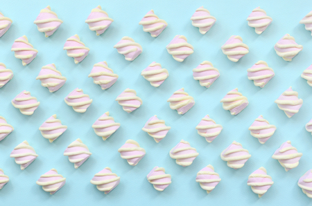 Colorful marshmallow laid out on blue paper background. pastel creative textured pattern. minimal.の写真素材