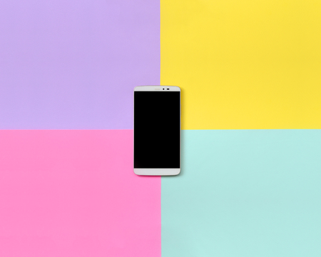 Modern smartphone with black screen on texture background of fashion pastel blue, yellow, violet and pink colors paper in minimal concept.の写真素材