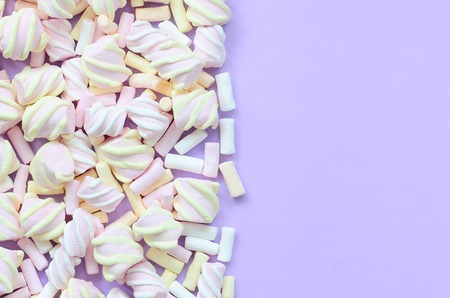 Colorful marshmallow laid out on violet paper background. pastel creative texture. minimal.の写真素材