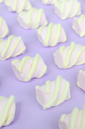 Colorful marshmallow laid out on violet paper background. pastel creative textured pattern. Perspective macro shot.の写真素材