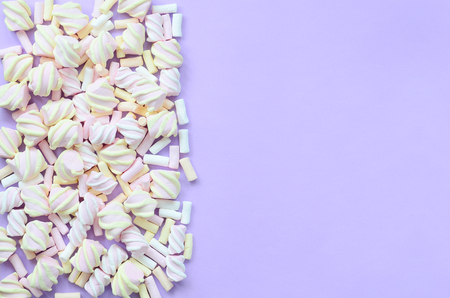 Colorful marshmallow laid out on violet paper background. pastel creative texture. minimal.の写真素材