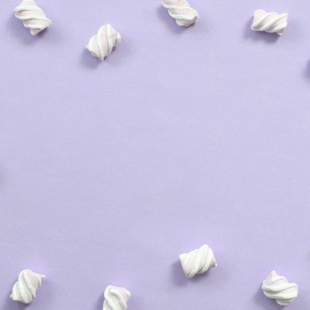 Colorful marshmallow laid out on violet paper background. pastel creative textured framework. minimal.の写真素材
