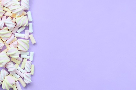 Colorful marshmallow laid out on violet paper background. pastel creative texture. minimal.の写真素材