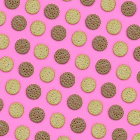 Pattern of a brown biscuits on a pink background. Trendy minimal concept of food and dessert....