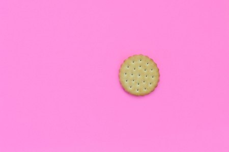 Miniature biscuit on a pink background. Trendy minimal concept of food and dessert. Abstract flat lay, top view.の写真素材