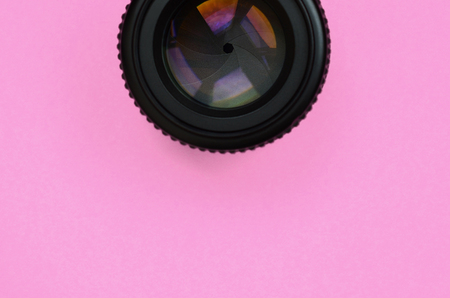 Camera lens with a closed aperture lie on texture background of fashion pastel pink color paper in minimal concept.の写真素材