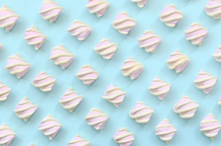 Colorful marshmallow laid out on blue paper background. pastel creative textured pattern. minimal.の写真素材
