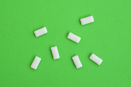 A few chewing gums lie on texture background of fashion pastel green color paper in minimal concept.の写真素材