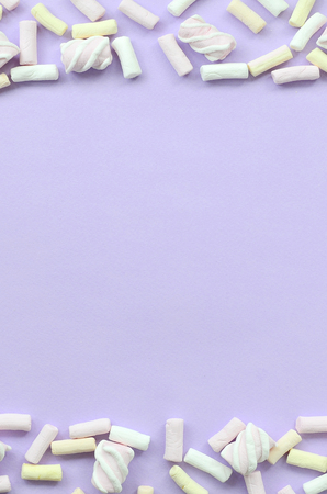 Colorful marshmallow laid out on violet paper background. pastel creative textured framework. minimal.の写真素材