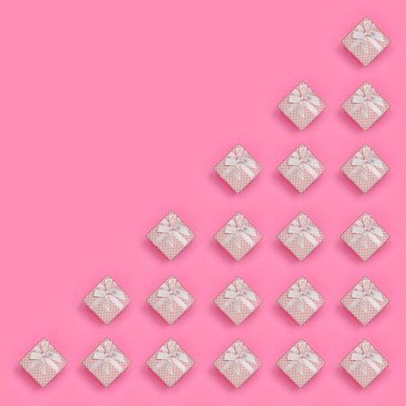 A lot of pink gift boxes lies on texture background of fashion pastel pink color paper in minimal...