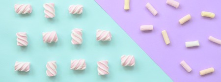 Colorful marshmallow laid out on violet and blue paper background. pastel creative textured pattern. minimal.の写真素材