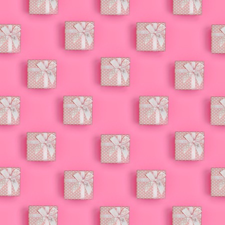 A lot of pink gift boxes lies on texture background of fashion pastel pink color paper in minimal concept. Abstract trendy pattern.の写真素材
