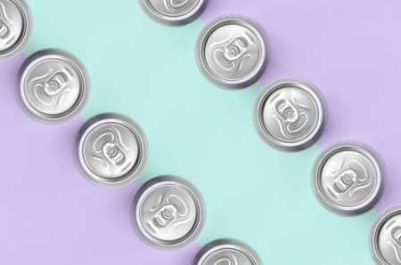 Many metallic beer cans on texture background of fashion pastel violet and blue colors paper in minimal concept.の写真素材