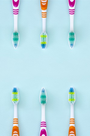 A lot of toothbrushes lie on a pastel blue background. Top view, flat lay. Minimal concept.の写真素材