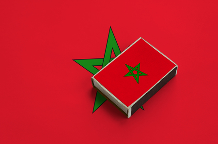 Morocco flag  is pictured on a matchbox that lies on a large flag.の写真素材