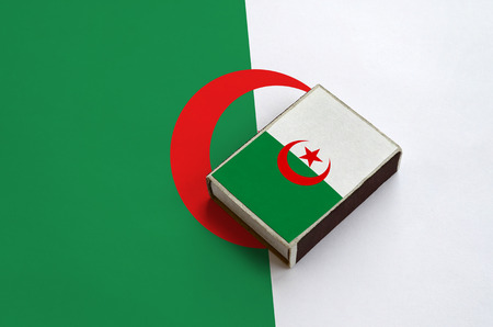 Algeria flag  is pictured on a matchbox that lies on a large flag.の写真素材