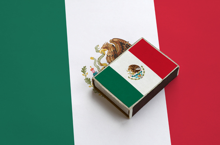 Mexico flag  is pictured on a matchbox that lies on a large flag.の写真素材