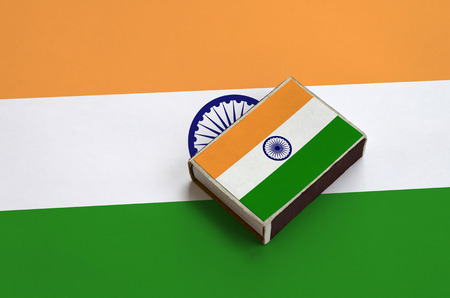 India flag  is pictured on a matchbox that lies on a large flag.の写真素材
