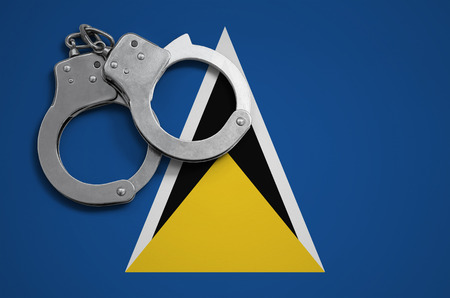 Saint Lucia flag  and police handcuffs. The concept of crime and offenses in the country.の写真素材
