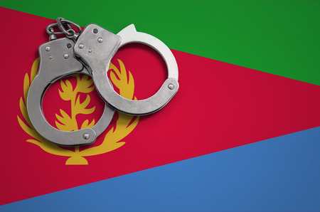 Eritrea flag  and police handcuffs. The concept of crime and offenses in the country.の写真素材