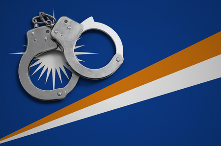 Marshall Islands flag  and police handcuffs. The concept of crime and offenses in the country.の写真素材