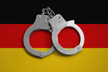 Germany flag  and police handcuffs. The concept of observance of the law in the country and protection from crime.の写真素材